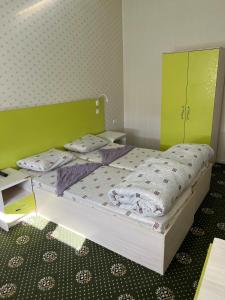 Anisa- Hostel في دوسهانبي: غرفة نوم مع سرير مع اللوح الأمامي الأخضر