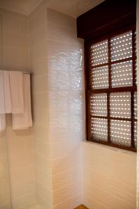 baño con ventana y toallas blancas en Casa De Quintãs, en Vila Real