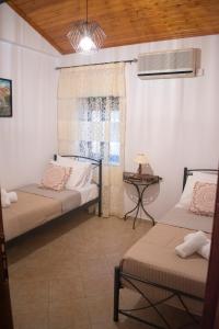 two beds in a room with a window at House of Harmony (Zounaki) in Kamisianá