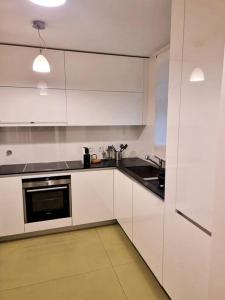 a kitchen with white cabinets and a sink and a stove at Central duplex apartment-full view of Douro river in Vila Nova de Gaia
