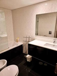 a bathroom with a sink and a toilet and a mirror at Central duplex apartment-full view of Douro river in Vila Nova de Gaia