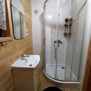 a bathroom with a shower and a sink at Domki Letniskowe Neptun in Chłopy