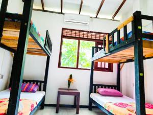 a room with two bunk beds and a table at Backpacker Galle Hostel in Galle
