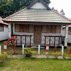 a small house with a fence in front of it at Bungalow le Charme, au bord de la mer 