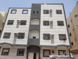 un edificio alto de color blanco con ventanas con barrotes en شقة مفروشة رقم 1 تبعد عن الحرم النبوي الشريف 3 كم, en Medina