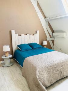 1 dormitorio con 1 cama grande con almohadas azules en Maison de vacances tout confort, piscine privée & équipements uniques, DORDOGNE, en Lamonzie-Saint-Martin