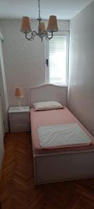 una piccola camera con letto e finestra di Apartman Na pjenu od mora Becici a Budua