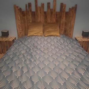 een bed in een slaapkamer met een houten hoofdeinde bij F2 Mass & Bo in Thaon-les-Vosges