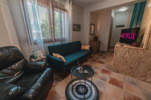 a living room with a couch and a television at AKAVA garden house in Volos