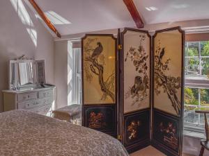 ein Schlafzimmer mit einer Kommode mit Gemälden darauf in der Unterkunft Willow Tree Cottage in Hayle