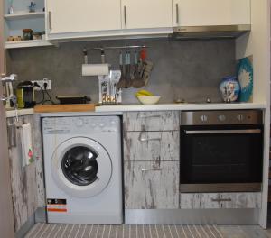 een keuken met een wasmachine bij Island mood studio in Porto Rafti