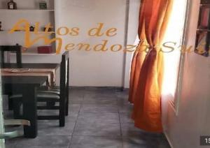 a dining room with a table and a curtain at Altos de Mendoza Suite in Mendoza
