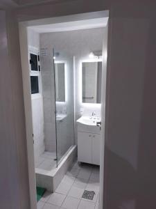 baño blanco con ducha y lavamanos en Altos de Mendoza Suite en Mendoza