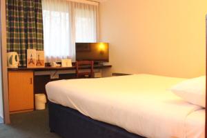 a hotel room with a bed and a desk with a computer at Campanile Hotel Hull in Hull