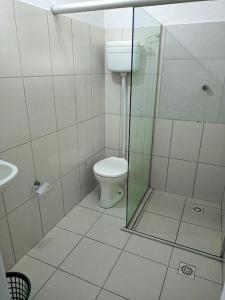 a bathroom with a toilet and a glass shower at Bimba Chalés Pé na Areia - Guaibim-Ba in Guaibim