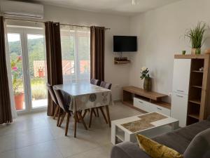 a living room with a table and a couch at Apartments Zahtila - Pina in Rabac