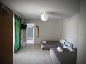 ein Schlafzimmer mit 2 Betten und einem grünen Vorhang in der Unterkunft Demis Apartments in Sidari
