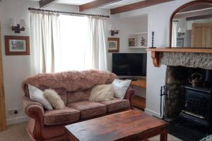 a living room with a couch and a fireplace at Cosy Town-Centre Cottage, St Austell, Cornwall in St Austell