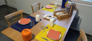 una mesa de madera con servilletas amarillas y naranjas. en La maison de Malaurie en Gruissan