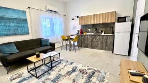 a living room with a couch and a kitchen at Cool one-bedroom Limeapartment with balcony in Haifa in Haifa