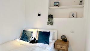 a bedroom with a panda bear sitting on a bed at Cool one-bedroom Limeapartment with balcony in Haifa in Haifa