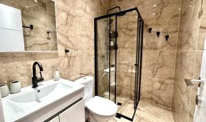a bathroom with a shower and a toilet and a sink at Cool one-bedroom Limeapartment with balcony in Haifa in Haifa