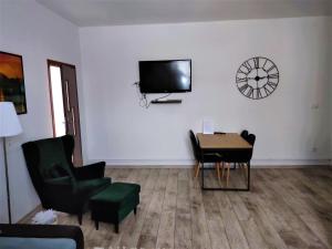 a living room with a table and a tv on a wall at Izerski Relaks in Świeradów-Zdrój