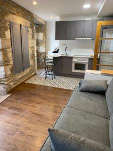 a living room with a couch and a kitchen at Apartamento foroplaza campo I in Lugo