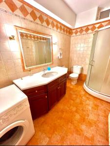 y baño con lavabo y lavadora. en Yellow House Oropos en Néa Palátia