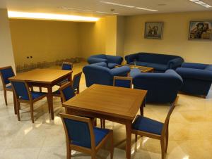 a waiting room with tables and blue chairs at Hotel Vila do Alba in Villalba