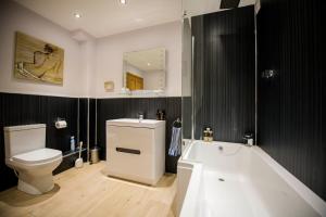 Un baño con bañera, inodoro y lavabo. en Tower Ridge Apartments, en Fort William 45 fotos más