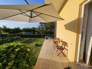 a patio with a table and an umbrella at Studio Ivona in Poreč