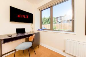 Cette chambre comprend un bureau avec un ordinateur portable et une fenêtre. dans l'établissement Prime Luxury, Heathrow, FreeParking, WiFi, Netflix, à Yiewsley