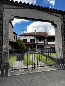 a gate to a house with a building behind it at Guest House Žerjal in Podnanos