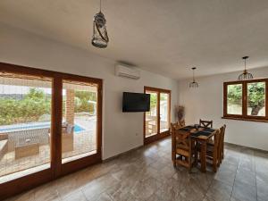 a dining room with a table and a television at Holiday homes Sintija in Rab