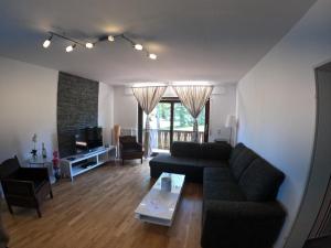 ein Wohnzimmer mit einem Sofa und einem TV in der Unterkunft Moderne 3 Zi Ferienwohnung in Winterberg