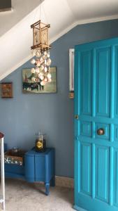 a blue room with a blue door and a chandelier at FILANGERI 116 in Santa Flavia