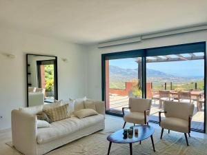 - un salon avec un canapé blanc et une grande fenêtre dans l'établissement Bright apartment in the hills of Elviria, à Malaga