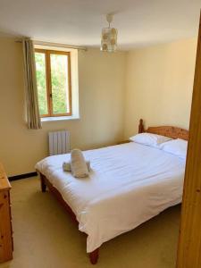 una camera da letto con un grande letto bianco e una finestra di Millstone Gite 1, two bed apartment + shared pool a Chassenon
