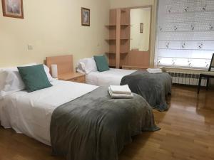 a hotel room with two beds with towels on them at Casa Nano in Sigüeiro