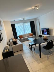 een woonkamer met een bank en een tafel bij Canal View One Bedroom Flat in Brussel