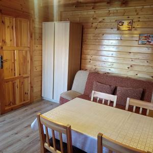 a dining room with a table and chairs in a cabin at Domki Letniskowe Neptun in Chłopy