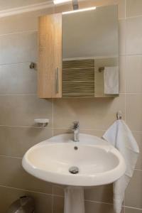 a bathroom with a white sink and a mirror at Elena Hara in Alikanas