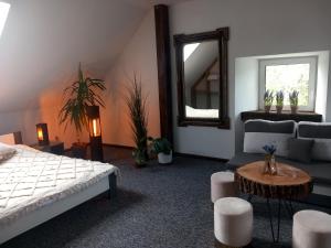 1 dormitorio con cama, espejo y sofá en Przystanek Szlakówka en Szczebrzeszyn