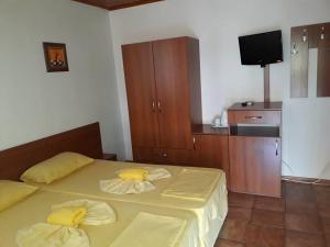 a bedroom with a bed with yellow sheets and a tv at Цар Калоян in Primorsko +27 photos