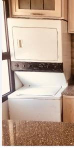um frigorífico congelador branco sentado numa cozinha em Lovely chalet 4- bedroom directly on the lagoon em El Alamein