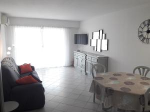 a living room with a couch and a table at Superbe Appartement FREJUS PLAGE in Fréjus