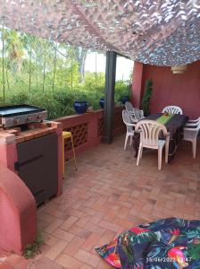 a patio with a table and chairs and a grill at Maison de vacances, proche de la plage in Fréjus