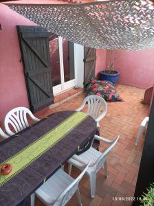 a patio with a table and chairs and a window at Maison de vacances, proche de la plage in Fréjus