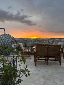 a patio with benches and a sunset in the background at Sunset Cave in Goreme